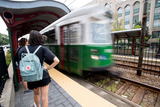 People stand on the platform as the MBTA pulls up