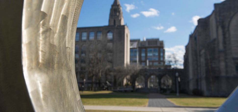 View of the Boston University College of Arts and Sciences building through the sculpture Counterpoint by Russell Jacques located on BU Beach.