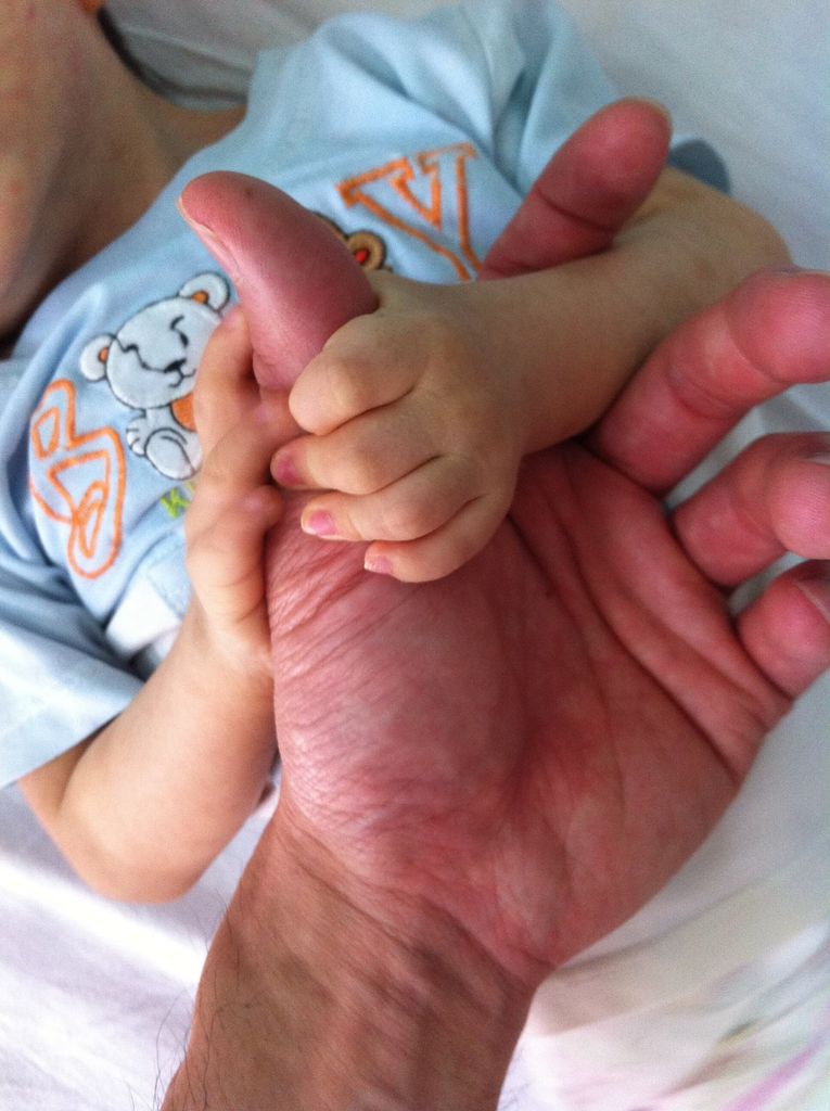 A small child holds Kinh Vu's hand during a visit to an orphanage