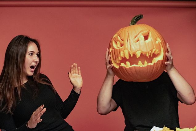 two terriers show off their scary jack-o-lantern