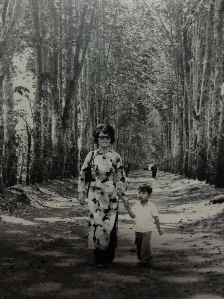 Viet holds his mother's hand as they walk in Ban Me Thuot rubber plantation 1973