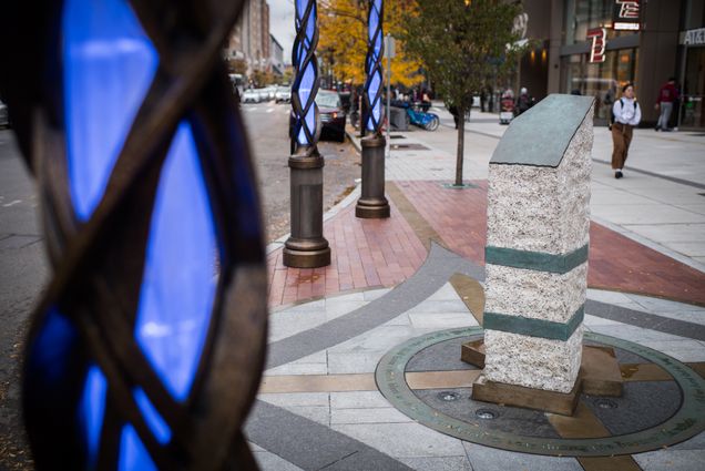 The Boston marathon marker surrounded by glowing spikes at dusk