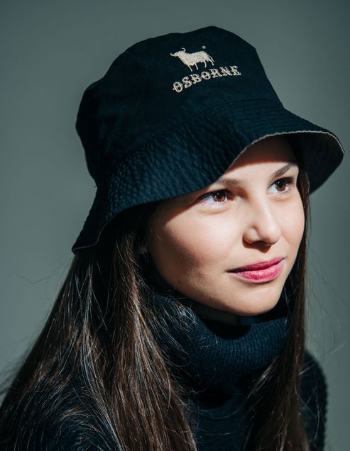 Silvia Velazquez-Gaztelu Ortega wears a reversible rainhat that saws "Osborne" on it