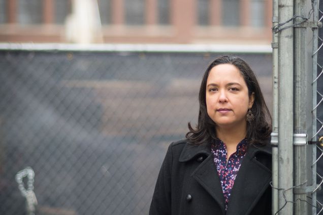 Portrait of Diana Ceballos, Boston University School of Public Health assistant professor of environmental health, in front of a Boston construction site.