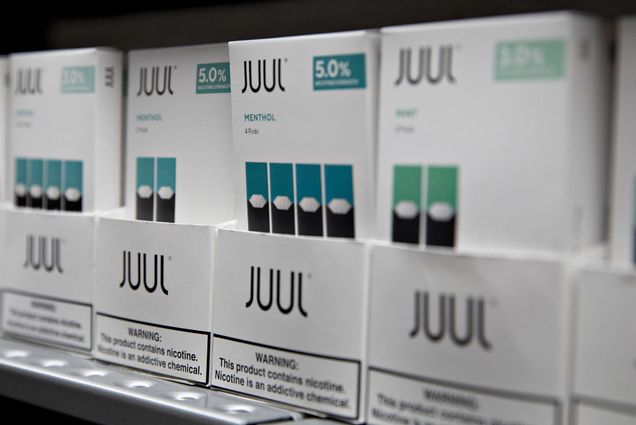 Packs of JUUL e-cigarettes on a display shelf focused on a pack of Menthol flavored vape package.