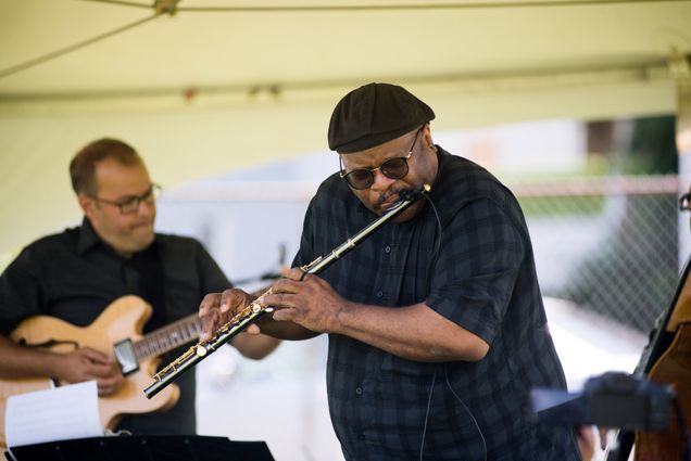 A photo of Lance Martin playing the flute on stage.