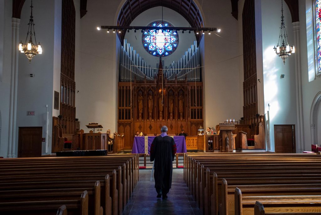 A photo of Rev. Hill facing the alter at an empty Marsh Chapel
