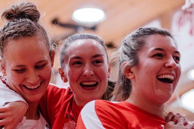 A photo of Nia Irving (Sargent’20) (from left), Liz Shean (COM’23), and Vanessa Edgehill (COM’20) after BU’s 46-44 quarterfinals victory over American University March 9