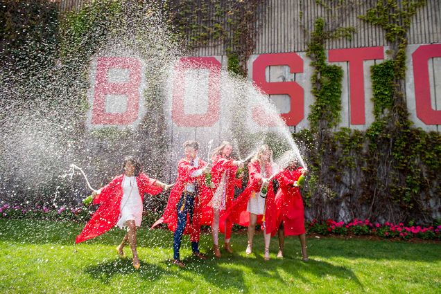 Boston University Class of 2019 graduates celebrate on Commencement day by popping and spraying bottles of champagne.