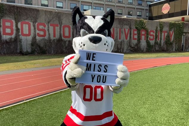A photo of Rhett holding a sign that reads "We miss you."