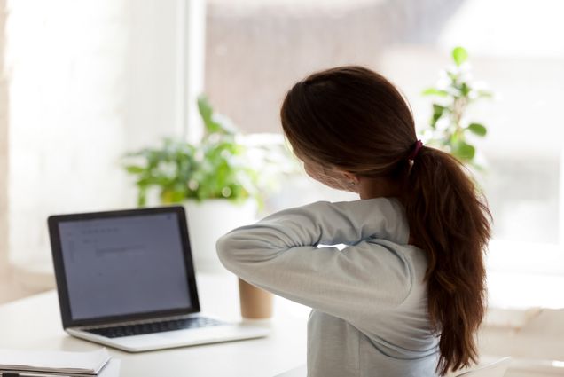 An image of a woman grabbing her neck in apparent discomfort