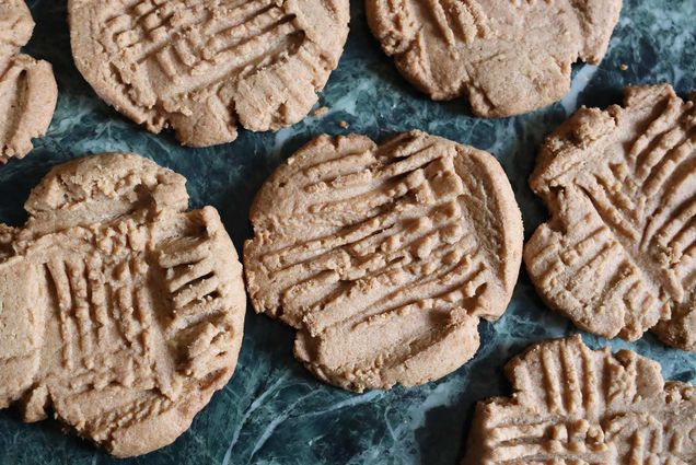 Shot of a bunch of peanut butter cookies on a kitchen counter.