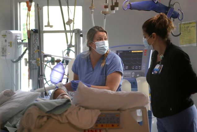 In this May 8, 2020, file photo, registered nurse Katie Hammond, left, works with another nurse on a patient in the COVID-19 Intensive Care Unit at Harborview Medical Center , in Seattle. The number of deaths in Washington because of the coronavirus has reached 1,000, the Washington State Department of Health reported Saturday, May 16, 2020. The agency added eight more deaths and listed the total number of confirmed cases at 18,288.