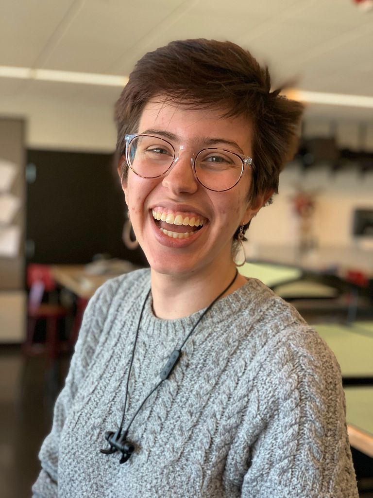 Portrait of Scene designer Saskia Martinez (CFA'20), this year's Kahn Award grand winner. She wears a gray sweater and has headphones around her neck.