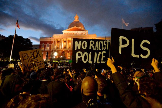 Protesters gather outside the Massachusetts State House during a demonstration over the death of George Floyd holding signs that say 'Black Lives Matter' and 'No Racist Police PLS' on May 31, 2020