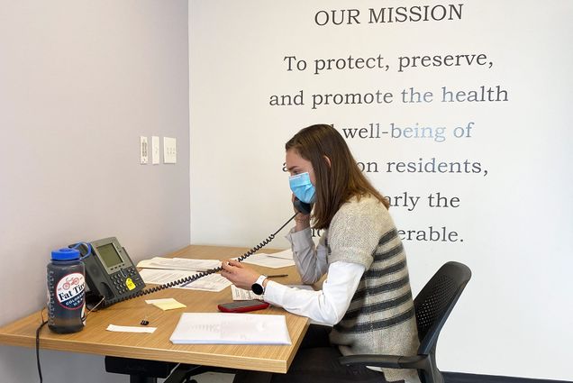 Photo of Natalia Kelley (SAR'22) in a mask talking on the phone as she volunteers as a contact tracer for the city of Boston.