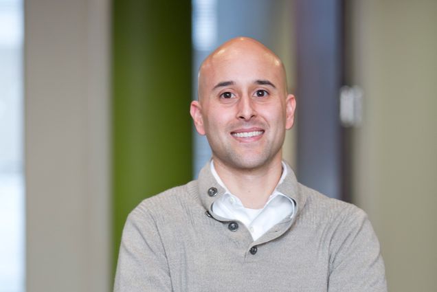 Headshot of Patrick Reyes who wears a gray sweater.