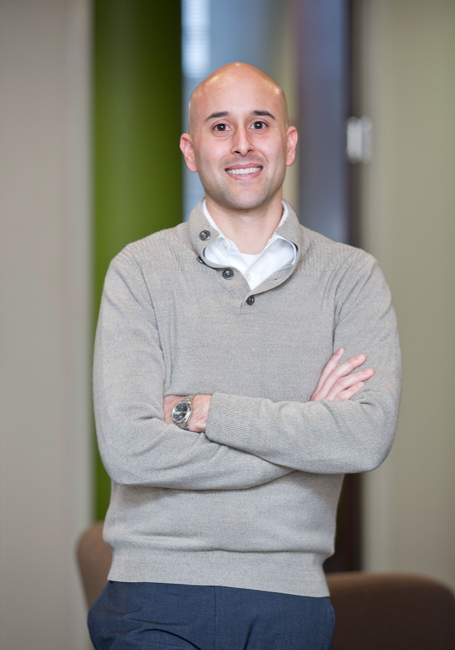 Headshot of Patrick Reyes who wears a gray sweater.