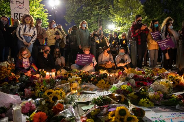 A photo of young people paying tribute to Ruth Bader Ginsburg outside of the Supreme Court following her death