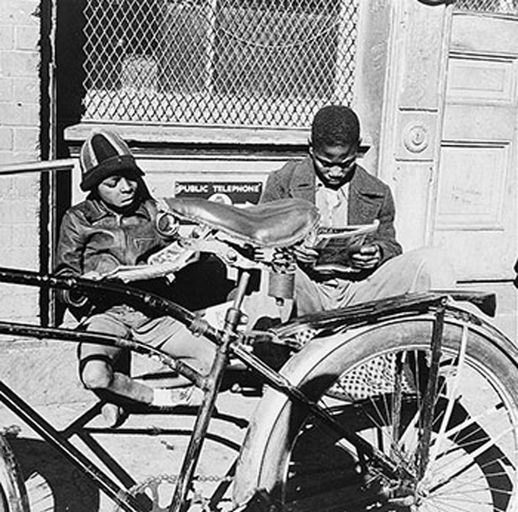 A photo of children sitting on a windowsill with a bicycle in the foreground