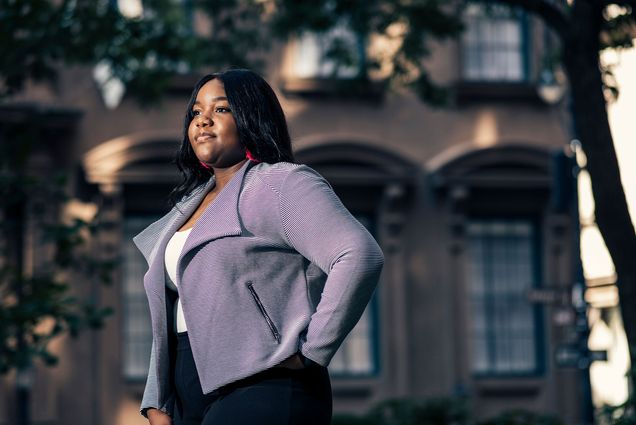 Photo of Delice Nsubayi in a purple blazer looking off into the middle distance.