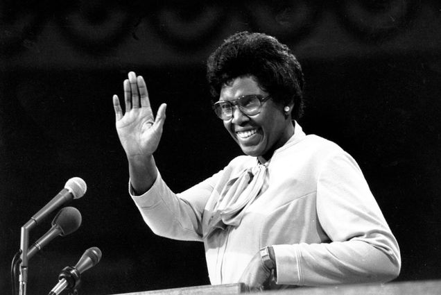 Black and white photo of Barbara Jordan waving and smiling during her ground-breaking speech at the podium of the 1976 Democratic National Convention in New York City.