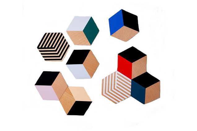 Photo of table tile coasters with colorful 3-D looking cube designs on a white background.