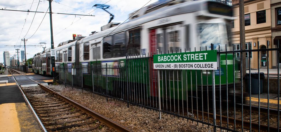 A photo of the MBTA green line running down Comm Ave.