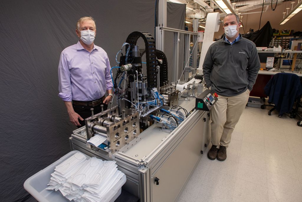 Andre Sharon (left), director of the Fraunhofer USA Center for Manufacturing Innovation at BU and lead engineer Holger Wirz, oversaw development of a mask-making machine that can produce 2,000 masks per hour.