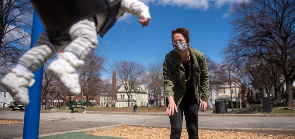 Bevin O'Gara pushes her son Henry on a swing at a park near their home in Jamaica Plain