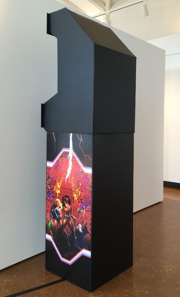 A photo of Jennifer Kilburn's piece in the show. It's a tall, black, structure with orange and red detailing on it.