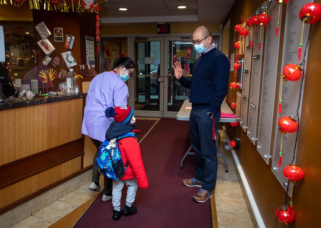 A photo of Ben Hires saying goodbye to a family as they leave Boston Chinatown Neighborhood Center on Ash Street