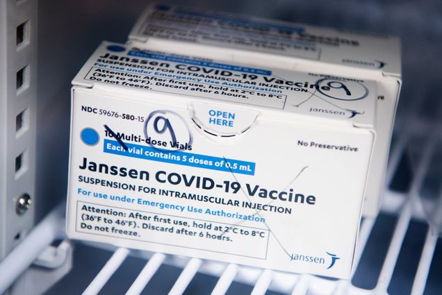 A photo of a box of Johnson and Johnson vaccines sitting on a shelf in a pharmacy