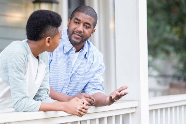 An African American father talks to his son