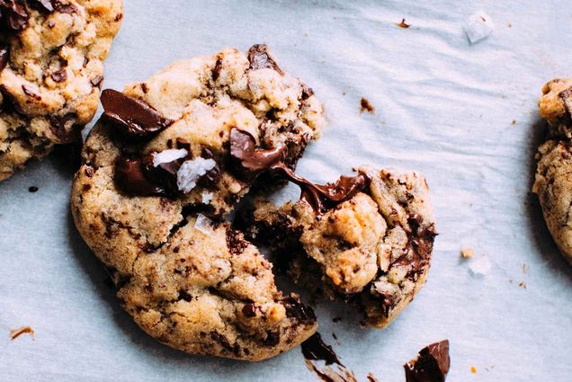 Gooey fresh baked chocolate chip cookies cool on a baking sheet.