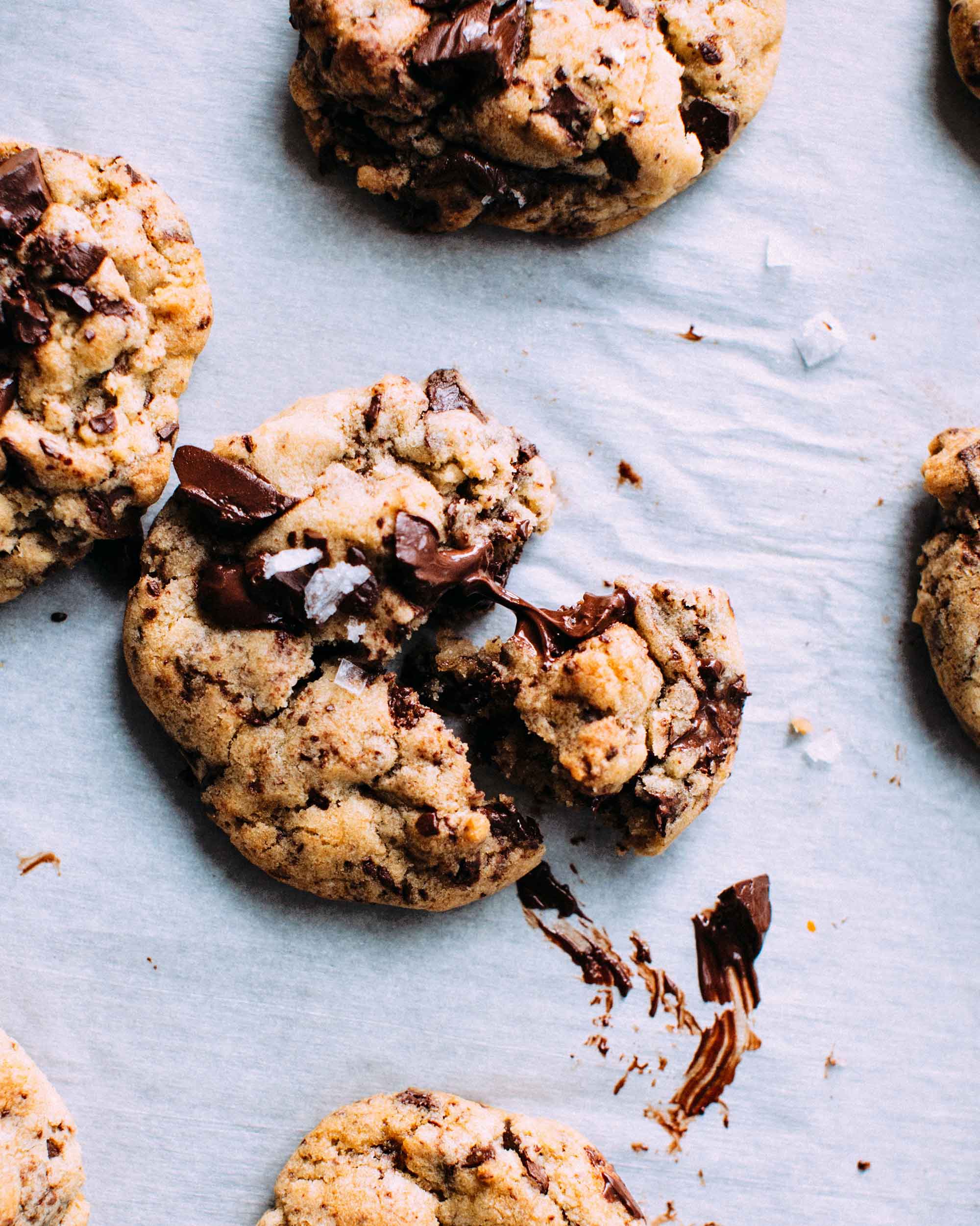 Gooey fresh baked chocolate chip cookies cool on a baking sheet.