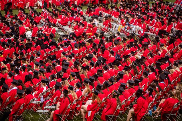 a photo of sitting BU grads wearing their red robes during Commencement