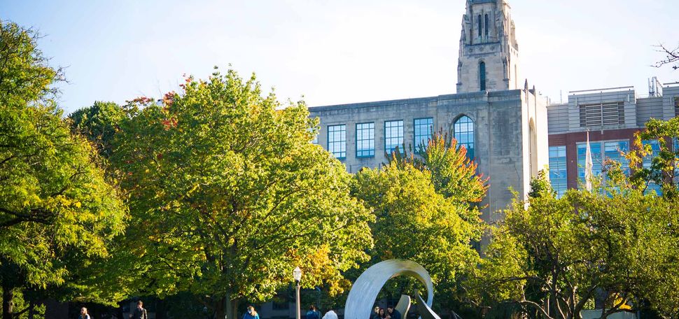 Early Fall view of a green BU Beach wtih the College of Arts & Sciences building in the background.
