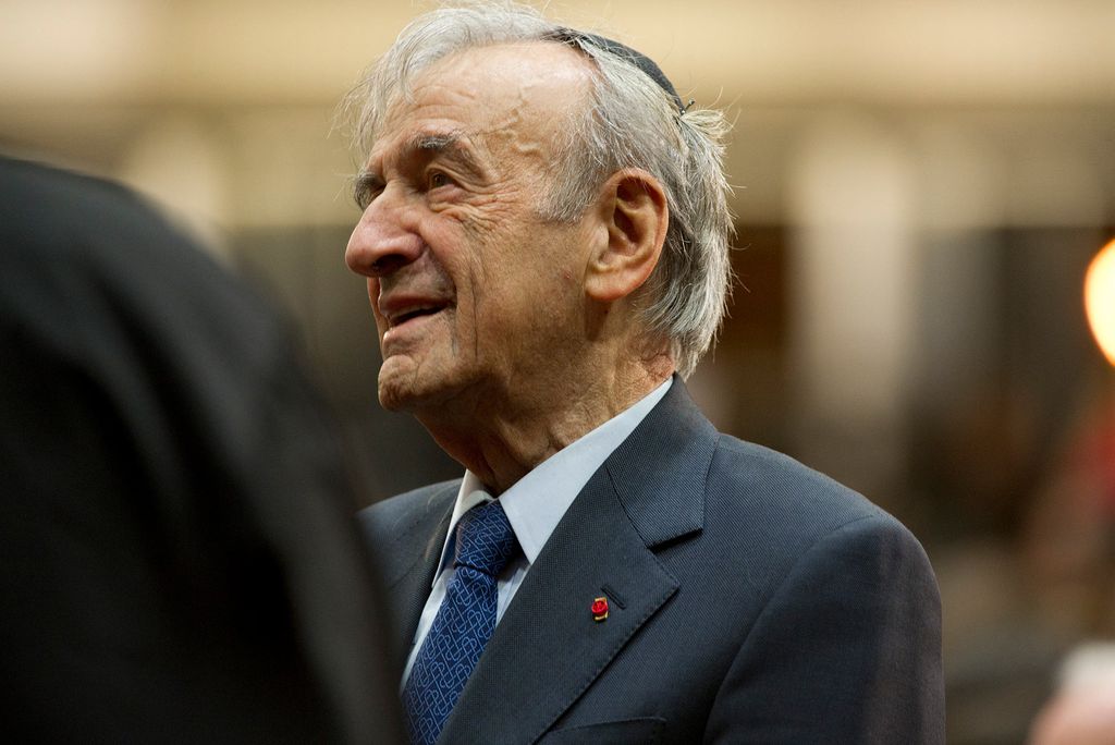 Photo of the late Elie Wiesel (Hon.’74), looking off to his right, and wearing a blue suit and tie. He has gray hair, and slightly smiles.