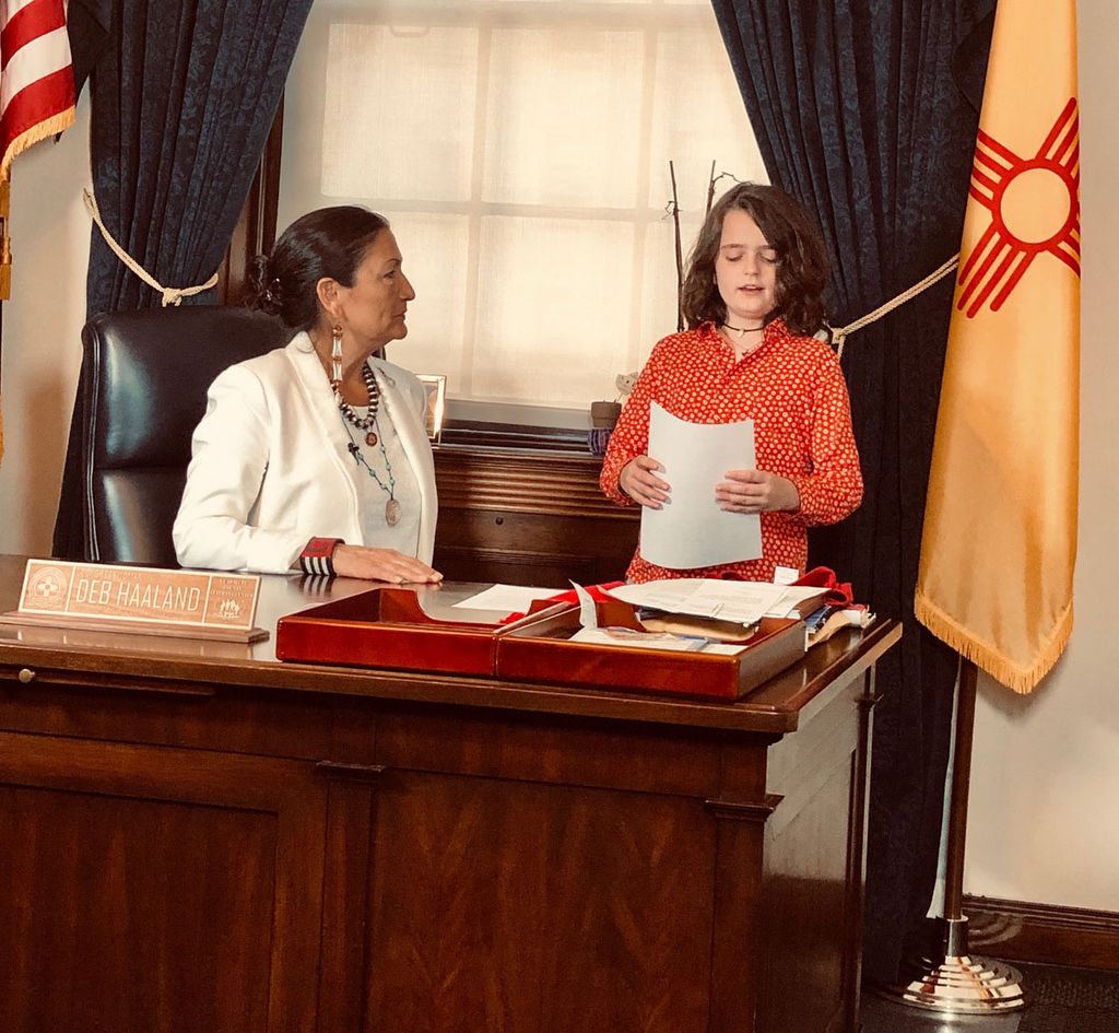 photo of Representative Deb Haaland (left) and Cary's son Otis (right) as he talks to her about the team’s name 