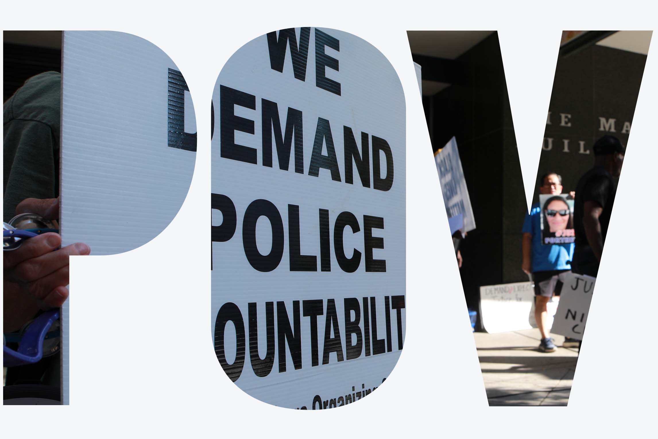 A protestor stands in front of the Houston Police Department headquarters holding a sign that says 'We Demand Police Accountability! Progressive Workers Organizing Committee.'