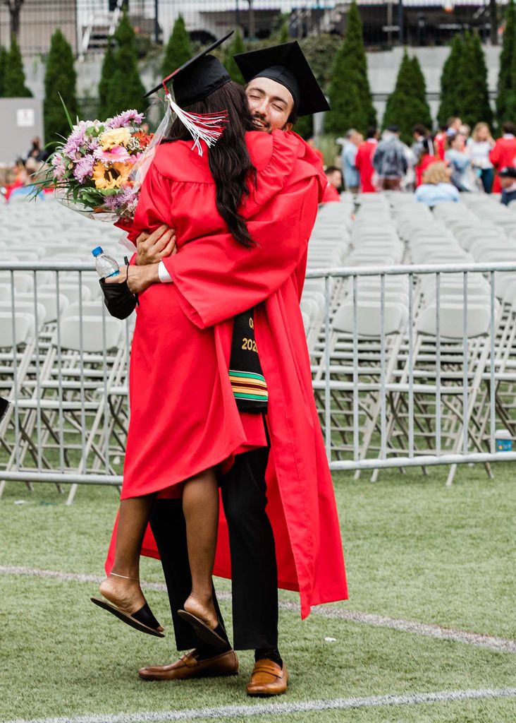 Two students embrace in a celebratory hug after Boston University's Class of 2020 graduation.
