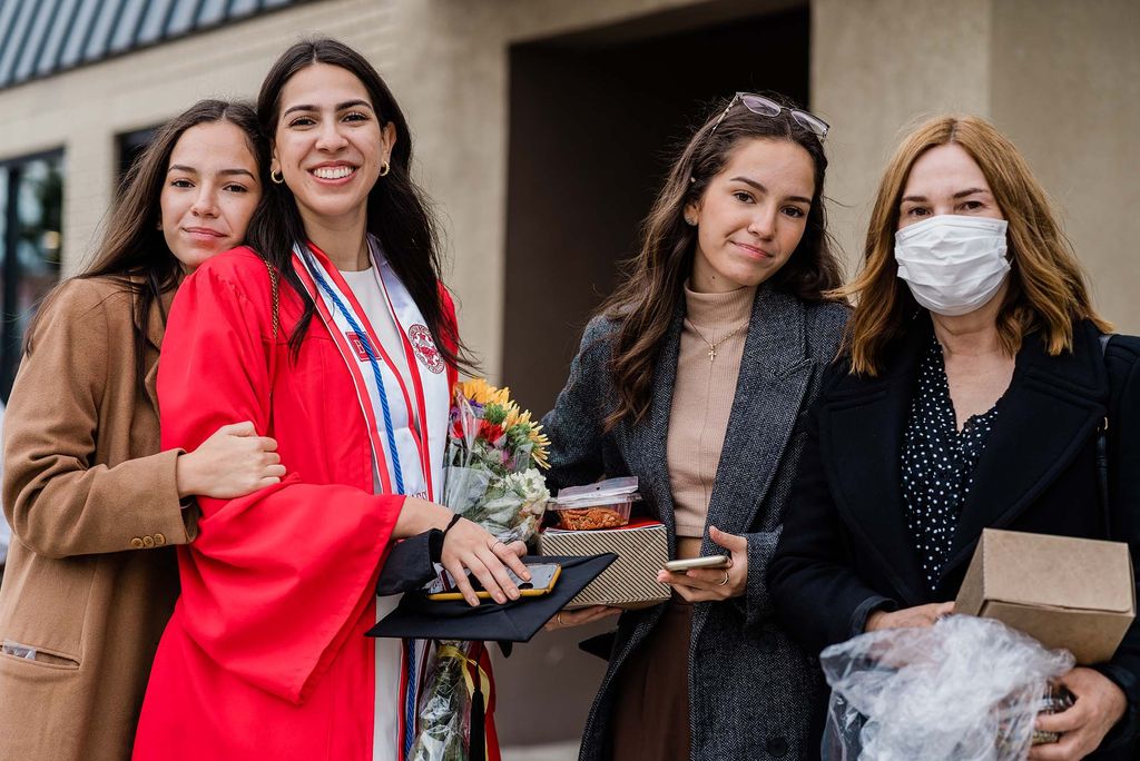 A BU Class of 2020 graduate poses for a photo with her family following Commencement.