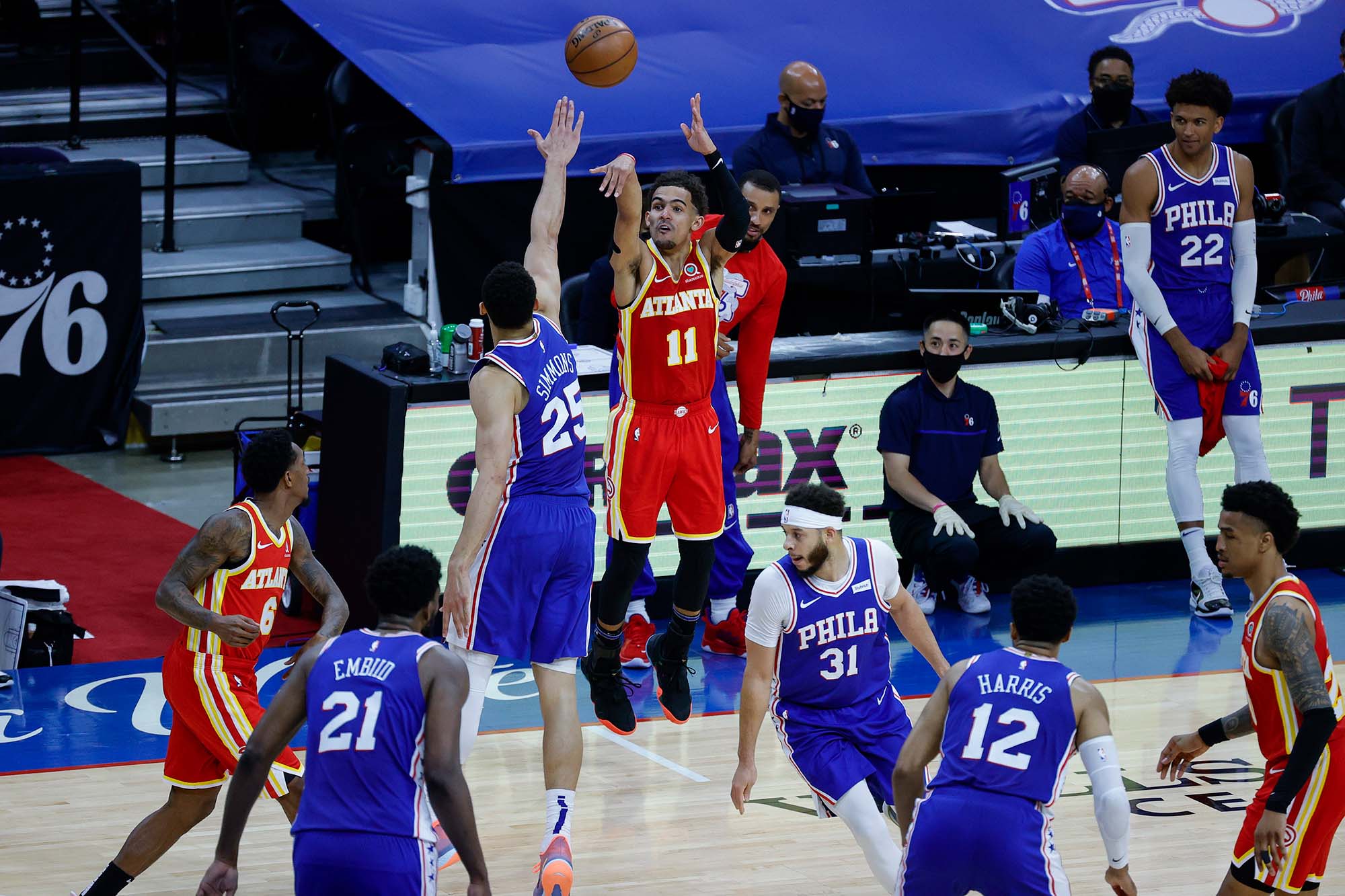 photo the Atlanta Hawks NBA match against the Philadelphia 76ers. The Hawks wear red jerseys as a player is mid-shot and the 76ers wear blue jerseys.