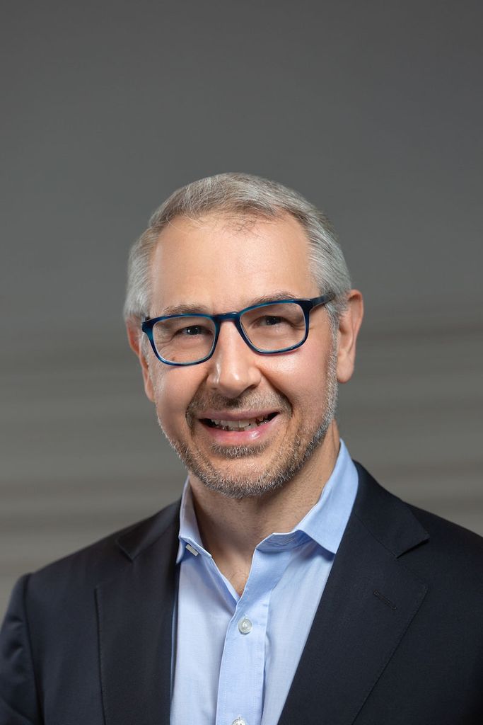 Photo of Chris Dellarocas, associate provost for digital learning and innovation. He wears a suit, has dark-rimmed glasses and grayish hair, and smiles.