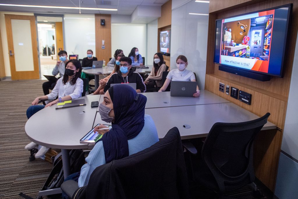 Photo of students in the Neglected Tropical Diseases course, including Humna Siddiqi (CAS’22), foreground, who looks towards the front of the classroom. She wears a dark blue hijab and a gray face mask. All of the students in the background wear face masks. 