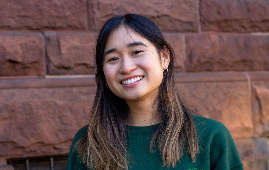 photo of Untangle Magazine creators Alyssa Yeh, an Asian American woman wearing a winter green sweater. She stands near a brownstone and smiles to the camera.