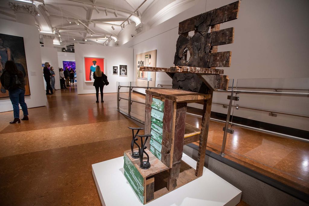 Photo of the sculpture "throne, roof and clapboard (2010)" by Chicago artist Theaster Gates. Using reclaimed wooden objects, the artist constructed a throne to shoeshining. Metal shoe holders sit at the bottom, green boards are at the center of the seat.