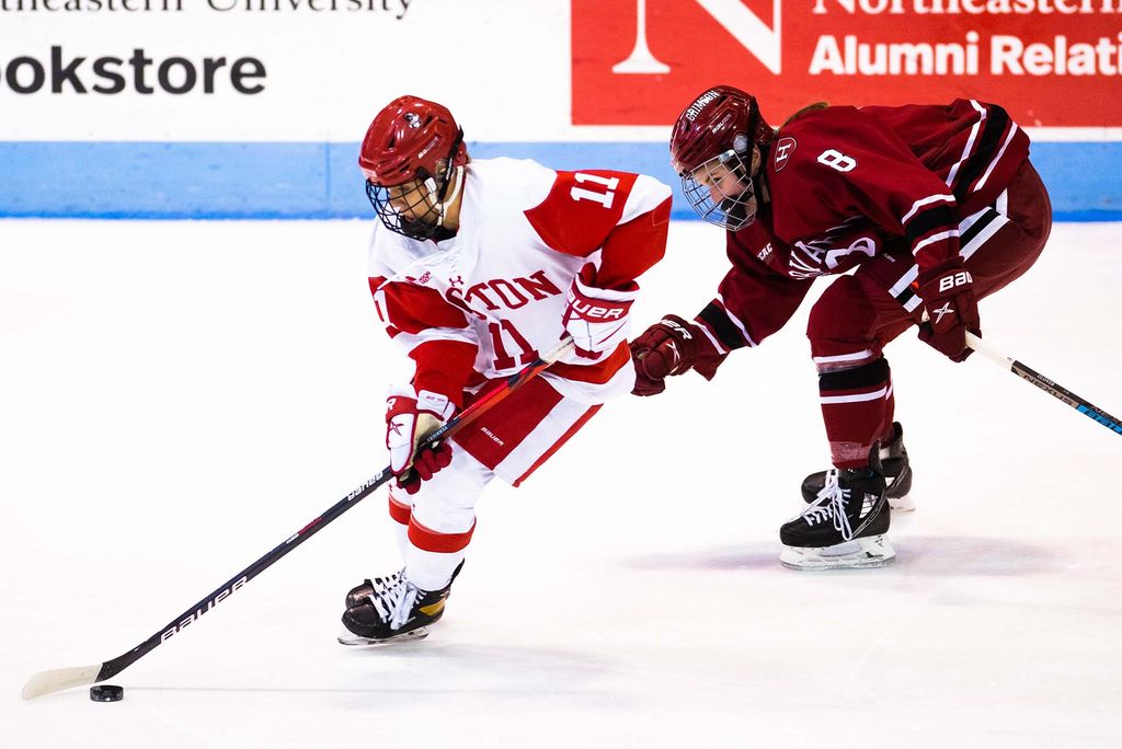 Photo of BU’s Mackenna Parker skating against Harvard’s Kate Glover during the women’s Beanpot Tournament at Matthews Arena on February 1, 2022.