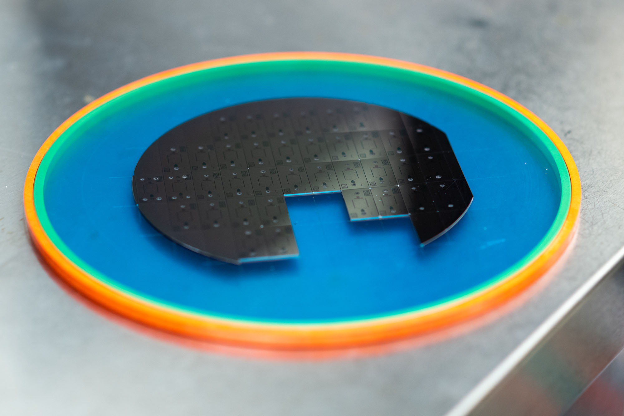 Photo of the microchips used in Selim Unlu's lab. Discs are atatched together and placed on a rainbow mat.
